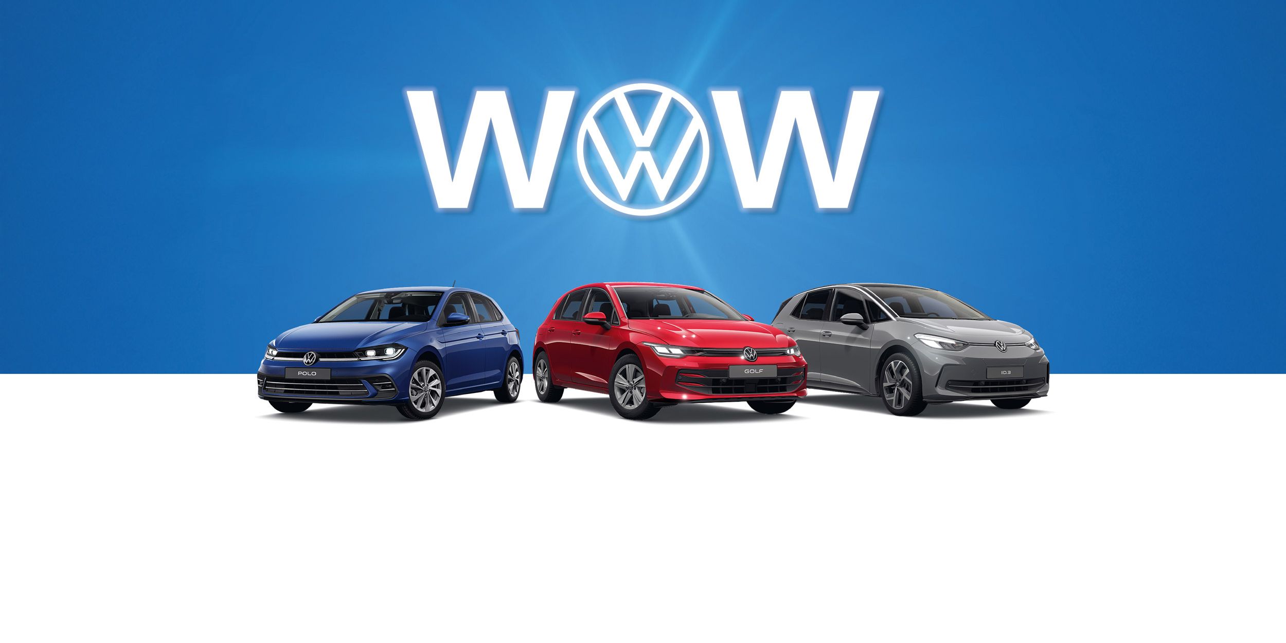 Drei Volkswagen-Autos, ein Polo, Golf und ID.3 stehen nebeneinander vor einem blauen Hintergrund. Hinter den Autos ist das Volkswagen-Logo und das Wort "WOW" zu sehen. Die Autos sind von links nach rechts blau, rot und grau.