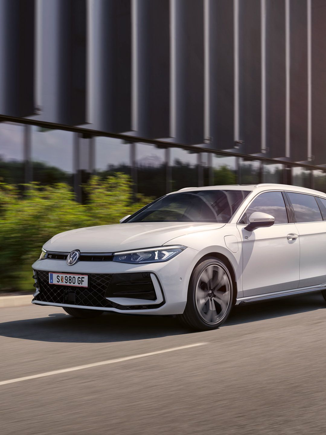 Ein weißer VW Passat R-Line fährt in einer Stadt